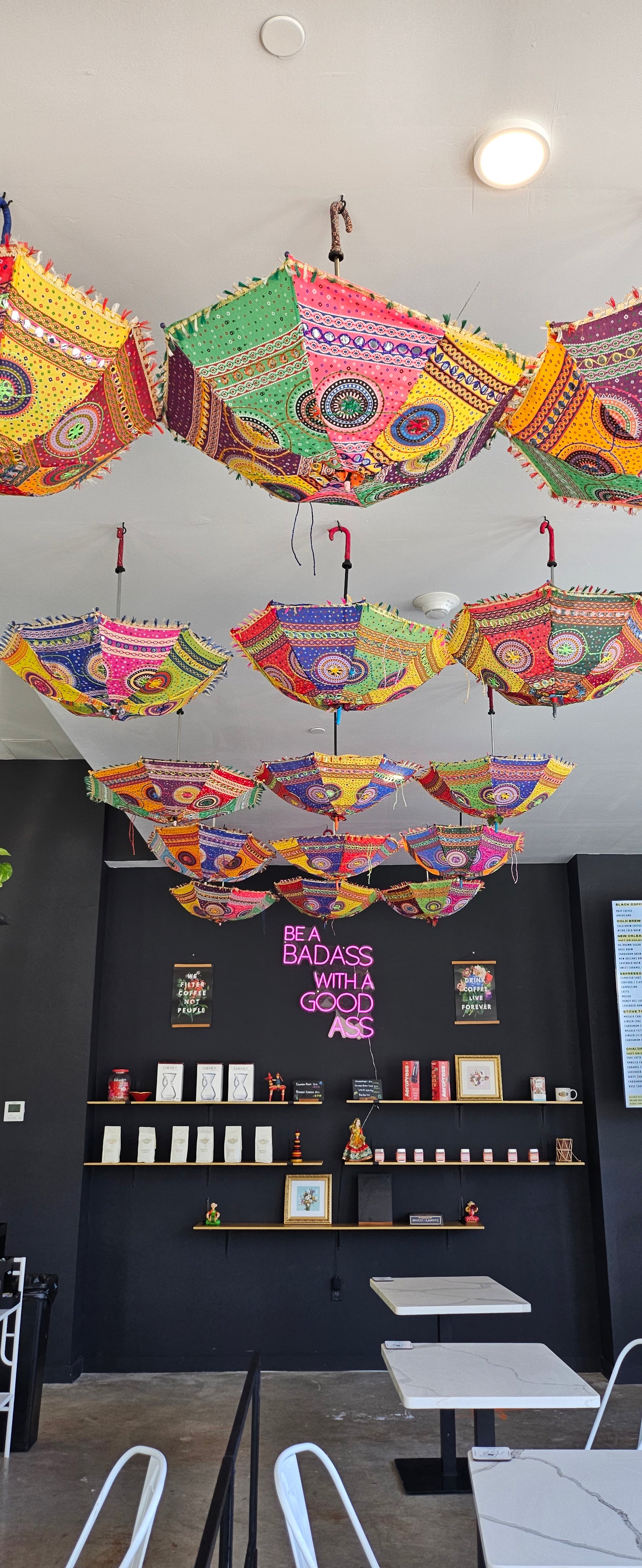 Inside Hidden Grounds at 144 Summit Avenue, with colorful umbrellas suspended above the café tables.